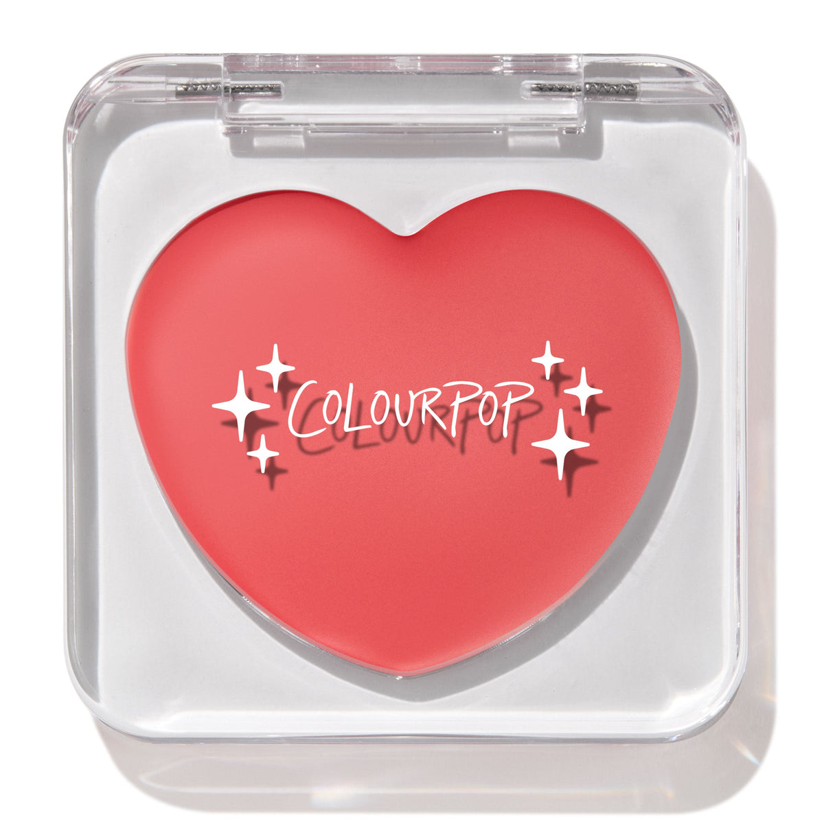 Heart-shaped ColourPop Lip and Cheek Balm in It’s a Look resting in a clear square compact with lid closed, showcasing a warm coral-pink shade and white ColourPop logo on a clean white background.