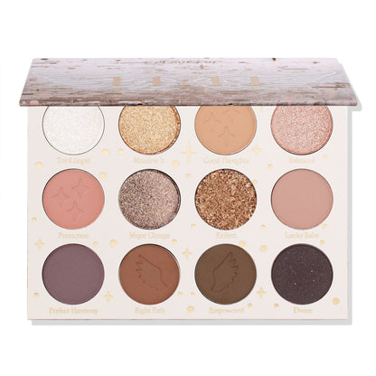 11:11 ColourPop Shadow Palette sits with lid half open, revealing 12 neutral shades - mattes and glittery metallics in ivory, gold, rose, taupe, warm browns, plum, and deep charcoal - with star/wing embossing and shade names on a white background.
