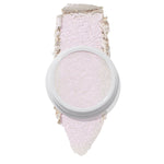 ColourPop Spellbound Super Shock Highlighter in a white pot, displaying an iridescent pink-lilac glow, with a broad swatch stroke beneath the pan showing its soft, shimmery payoff on a clean white background.
