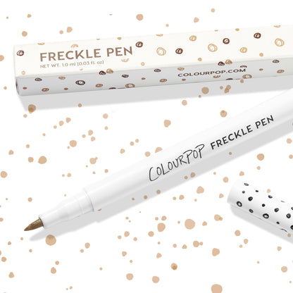 Soft Brown ColourPop Freckle Pen uncapped, felt-tip applicator ready to dot natural-looking freckles, shown with polka-dot cap and matching box on a white background speckled with brown spots; 1.0 ml makeup pen for faux freckles.
