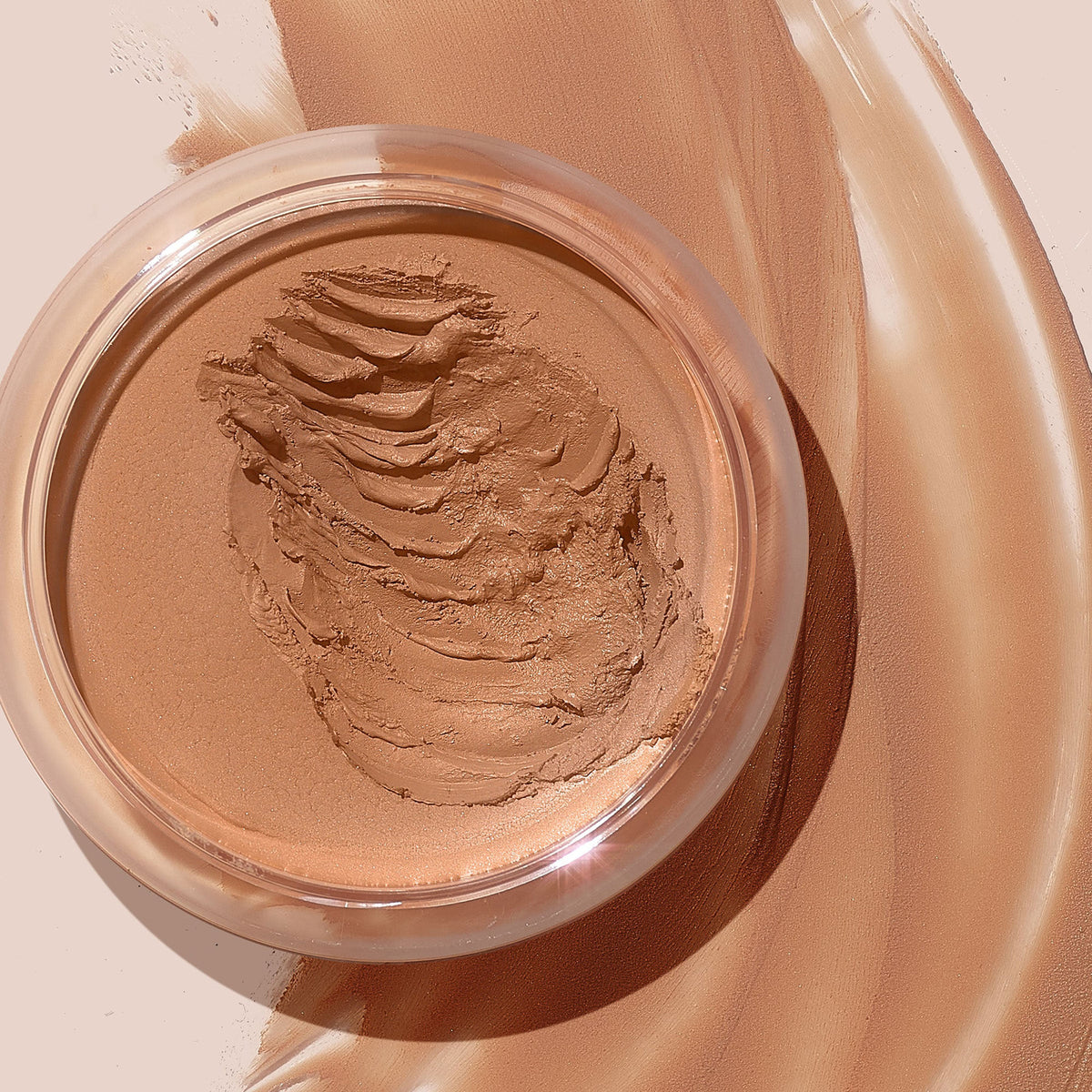Medium shade ColourPop SOL Face & Body Bronzing Balm displayed in an open clear jar, creamy whipped formula with visible swipe marks, surrounded by smooth tan swatches on a nude backdrop for a sun-kissed face and body glow.