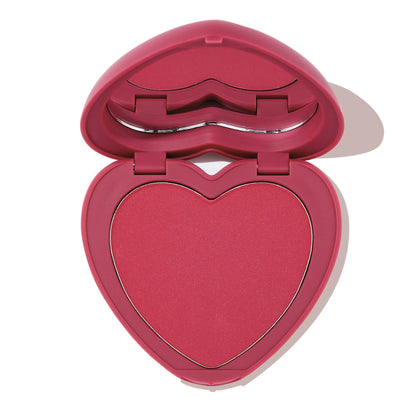 Babycakes ColourPop Pressed Powder Blush shown open, revealing a heart-shaped rosy pink pan in a matching pink compact with a lip-shaped mirror detail, photographed on a white background.