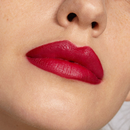 Bold lips wearing Bichette ColourPop Lippie Pencil, a rich cherry red liner filling and defining the mouth with a smooth matte finish; tight close-up highlights crisp edges and saturated pigment on fair skin.