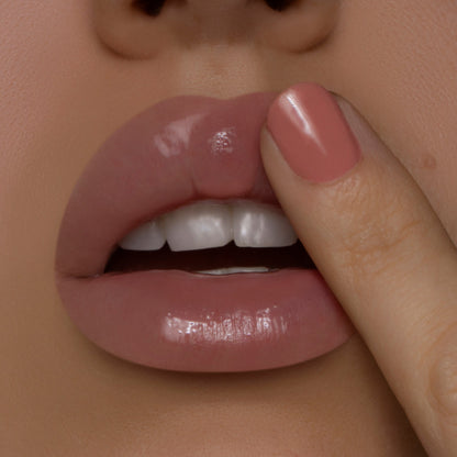 Glossy lips apply Coconut ColourPop Lip Mask with a fingertip, revealing a smooth, hydrating shine in a studio close-up with a pink-manicured nail, highlighting the lip mask’s moisture-rich finish.