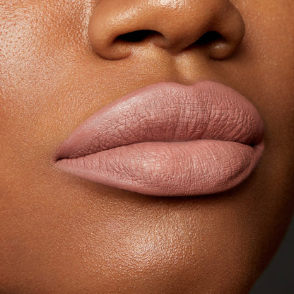 Lips wearing Beeper, a muted mauve nude, outlined and filled with the ColourPop Lippie Pencil for a smooth matte finish; extreme close-up beauty swatch on medium-brown skin highlighting crisp liner edges and velvety texture.