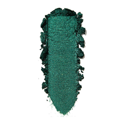 Empire Super Shock Shadow by ColourPop swatched in a single elongated smear, showing a rich metallic emerald green with fine shimmer and soft crumbled edges on a white background to highlight texture and pigment payoff.