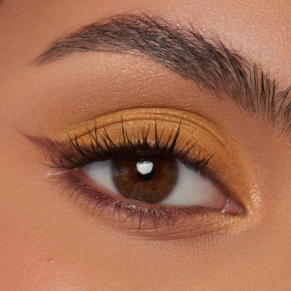 Gold shimmer eyeshadow sweeps across a single eyelid with a soft tan crease and subtle burgundy flick, lashes defined, showcasing the warm payoff of the Best Day Ever ColourPop Shadow Palette in a close-up beauty swatch.