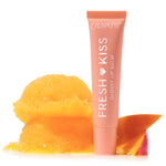 ColourPop Fresh Kiss Glossy Balm in Mango Sorbet stands upright in a coral squeeze tube labeled “Fresh Kiss,” beside two melting scoops of mango sorbet and a mango slice on a clean white background.