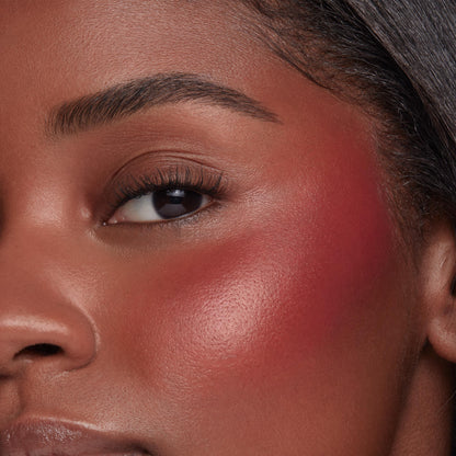 ColourPop Liquid Blush Royal Flush applied on a model’s cheek, rosy-red pigment blended from apple to temple with a dewy, luminous finish, close-up showcasing smooth, even payoff beside the eye.
