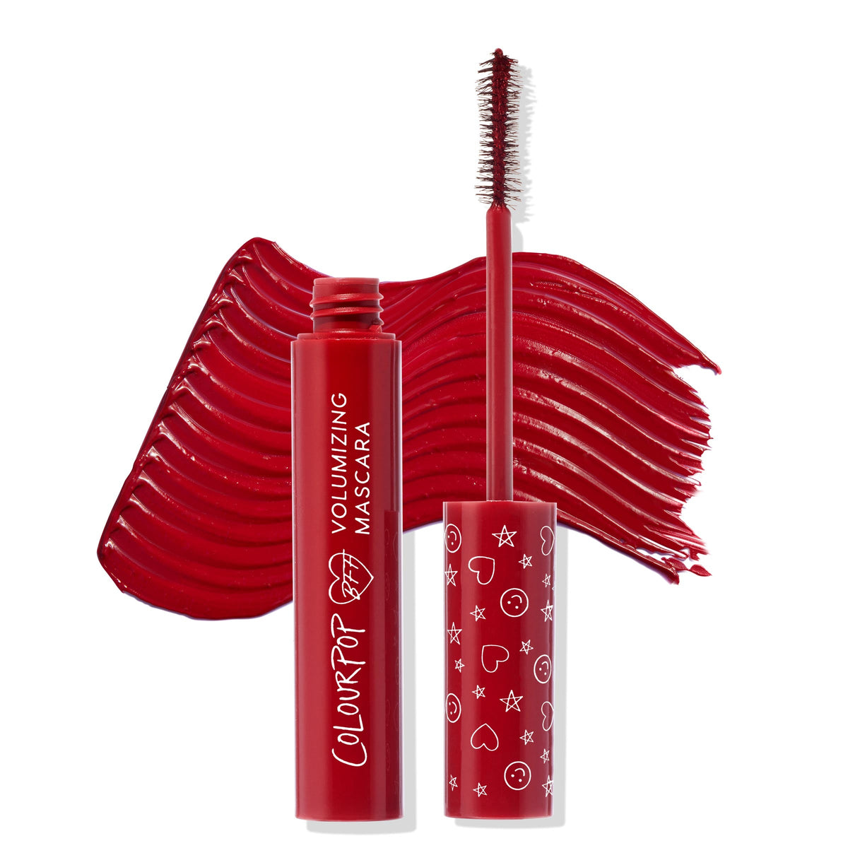 ColourPop BFF Mascara Left on Red with open tube and wand coated in rich red, wand raised beside cap printed with hearts, stars, and smiley icons, set before a bold red swatch to showcase the volumizing formula in a clean studio shot.