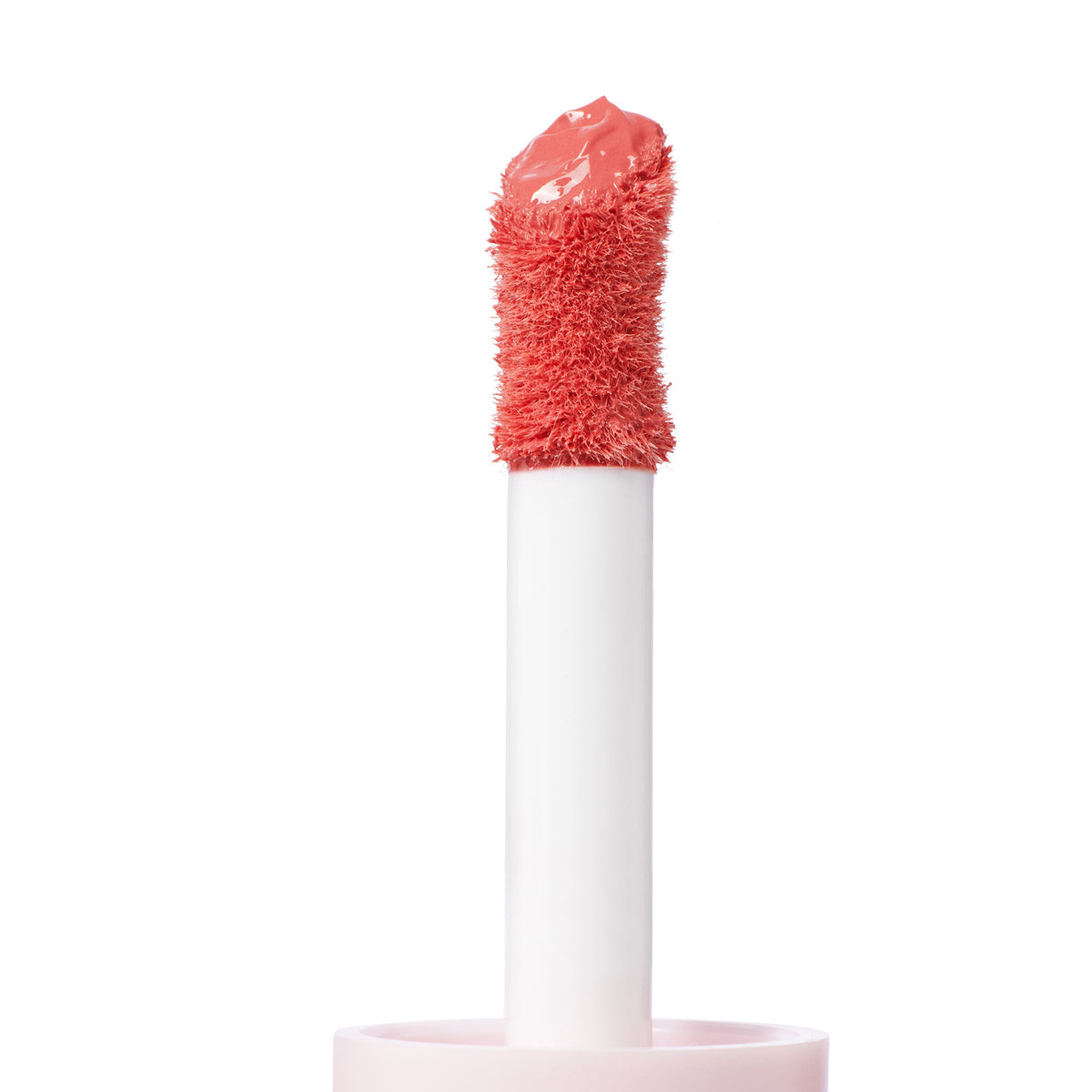 Doe-foot applicator coated in Super Shy, a peachy coral ColourPop Liquid Blush, showcasing plush bristles and creamy, glossy texture on a white wand in a close-up studio shot against a clean white background.