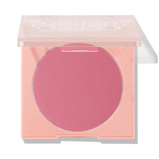 New to U ColourPop Pressed Powder Blush compact displaying a rosy pink pan, lid half-open on a peach square case with a clear top, photographed against a white studio background with a soft shadow.