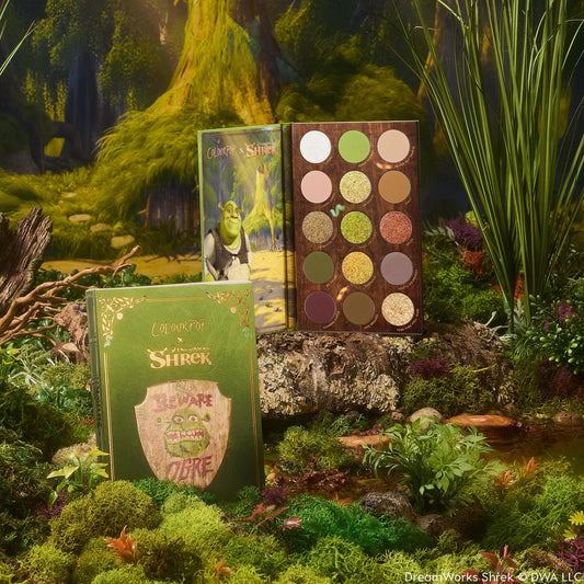 ColourPop Shadow Palette Beware Ogre opens to display 15 earthy green, brown, and gold mattes and shimmers, paired with a matching green box and Shrek artwork, styled in a mossy swamp setting.