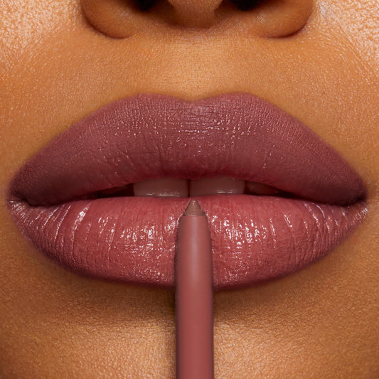 ColourPop So Juicy Plumping Lip Liner with Peptides in ETA defining glossy rosy‑mauve lips, pencil tip centered on the cupid’s bow in an extreme close‑up, showing smooth precise payoff for lip shaping and plumping.