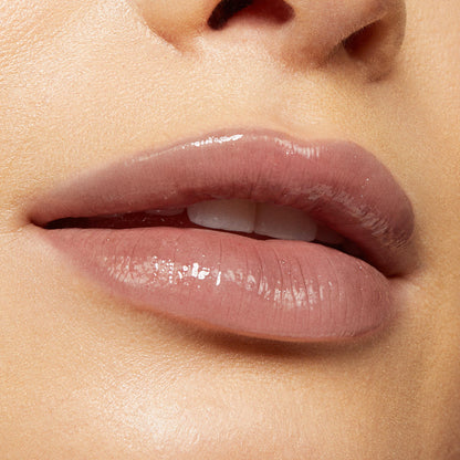 Glossy nude‑pink lips wearing Team Jacob, a ColourPop Lux Lip Oil, showcasing a high‑shine, sheer finish and smooth texture in a tight beauty close‑up.