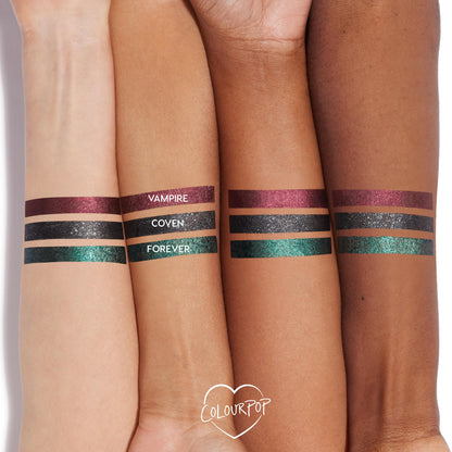 ColourPop Graphix Ink Liner “I Know What You Are” swatched on three arms: metallic burgundy Vampire, black‑silver sparkle Coven, and emerald‑teal shimmer Forever, shown in neat stripes across light to deep skin tones in a studio close‑up.
