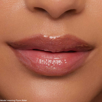 Glossy nude-pink lips wearing ColourPop Ultra Glossy Lip in Flynn Rider, reflecting a high-shine finish with subtle shimmer in a tight face close-up, showcasing smooth, hydrated texture for everyday wear.