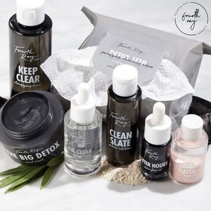 All Clear Purifying Serum face serum by Fourth Ray Beauty in a clear glass dropper bottle stands centered among Clean Slate exfoliator, Keep Clear tonic, Detox Sesh wipes, and a clay mask on white marble - a ColourPop Face Serum.