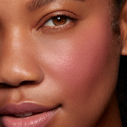 Verified ColourPop Lip and Cheek Balm delivering a dewy rosy flush on the cheek and a soft lip tint, shown in a studio close-up of a model’s face to highlight smooth, buildable color and a natural glow.