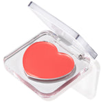 Heart-shaped coral pink Baby Bunny balm sitting in a half-open clear acrylic compact on a white background, a creamy multipurpose ColourPop Lip and Cheek Balm for dewy color on lips and cheeks.