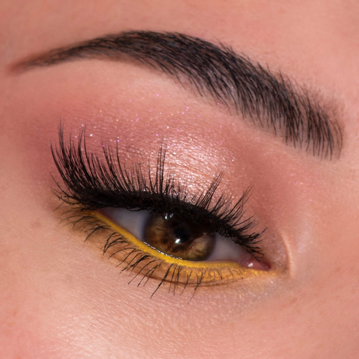 Close-up eye wearing sparkly pink-champagne shadow, long wispy lashes, and vivid honey-yellow waterline liner, showcasing the Sweet as Hunny Eye & Lip Set, a ColourPop Eye & Lip Set for bright, playful spring makeup.