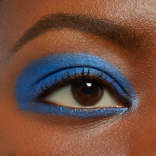 Close-up eyelid wearing Rain Check, a vivid metallic cobalt blue ColourPop Shadow Stix, swept across the upper lid and lower lash line with a smooth, opaque finish, defining lashes and brow for a bold eye look.